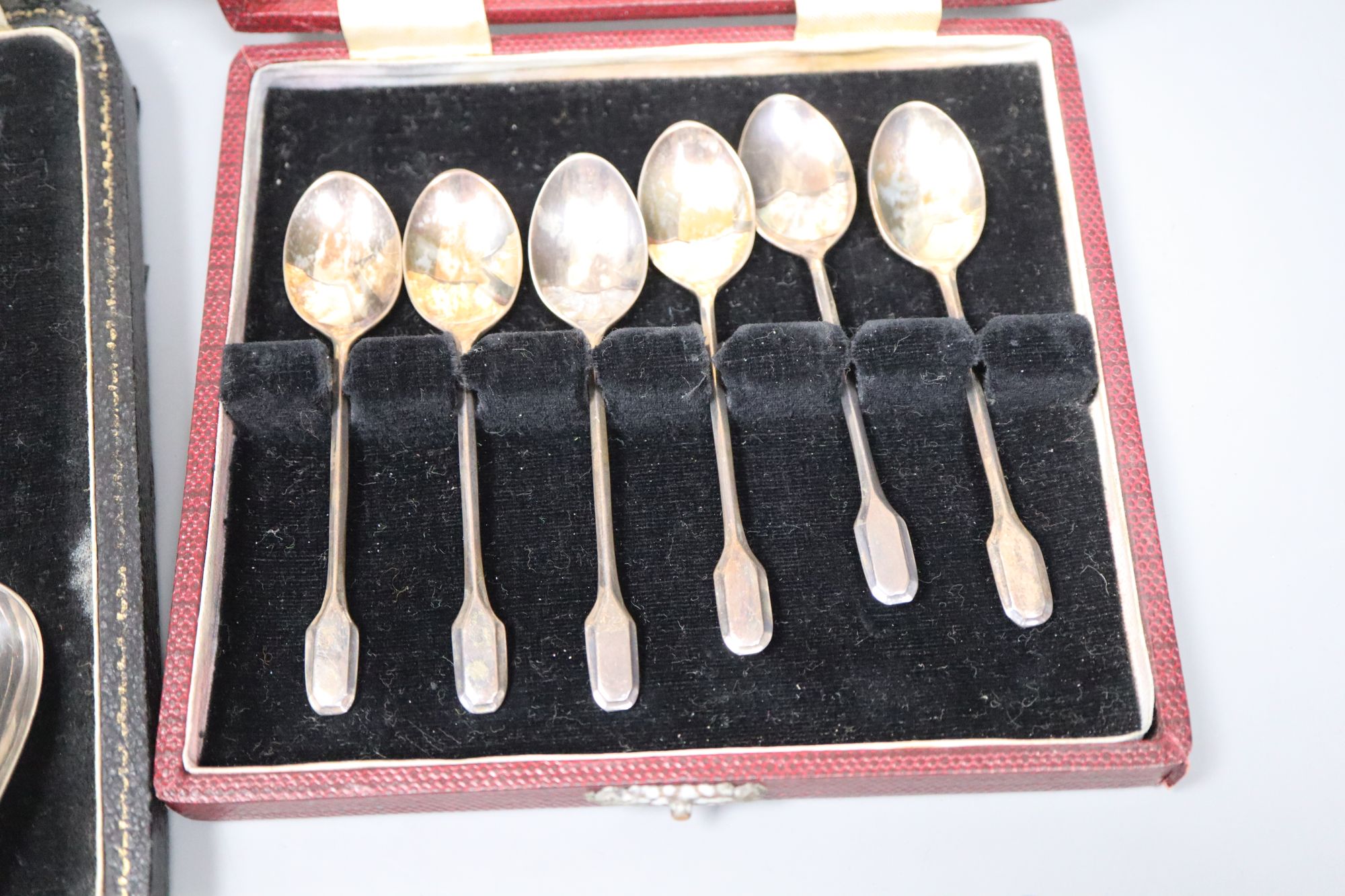 A set of six silver grapefruit spoons and a set of six silver coffee spoons, both cased, 5.5oz.
